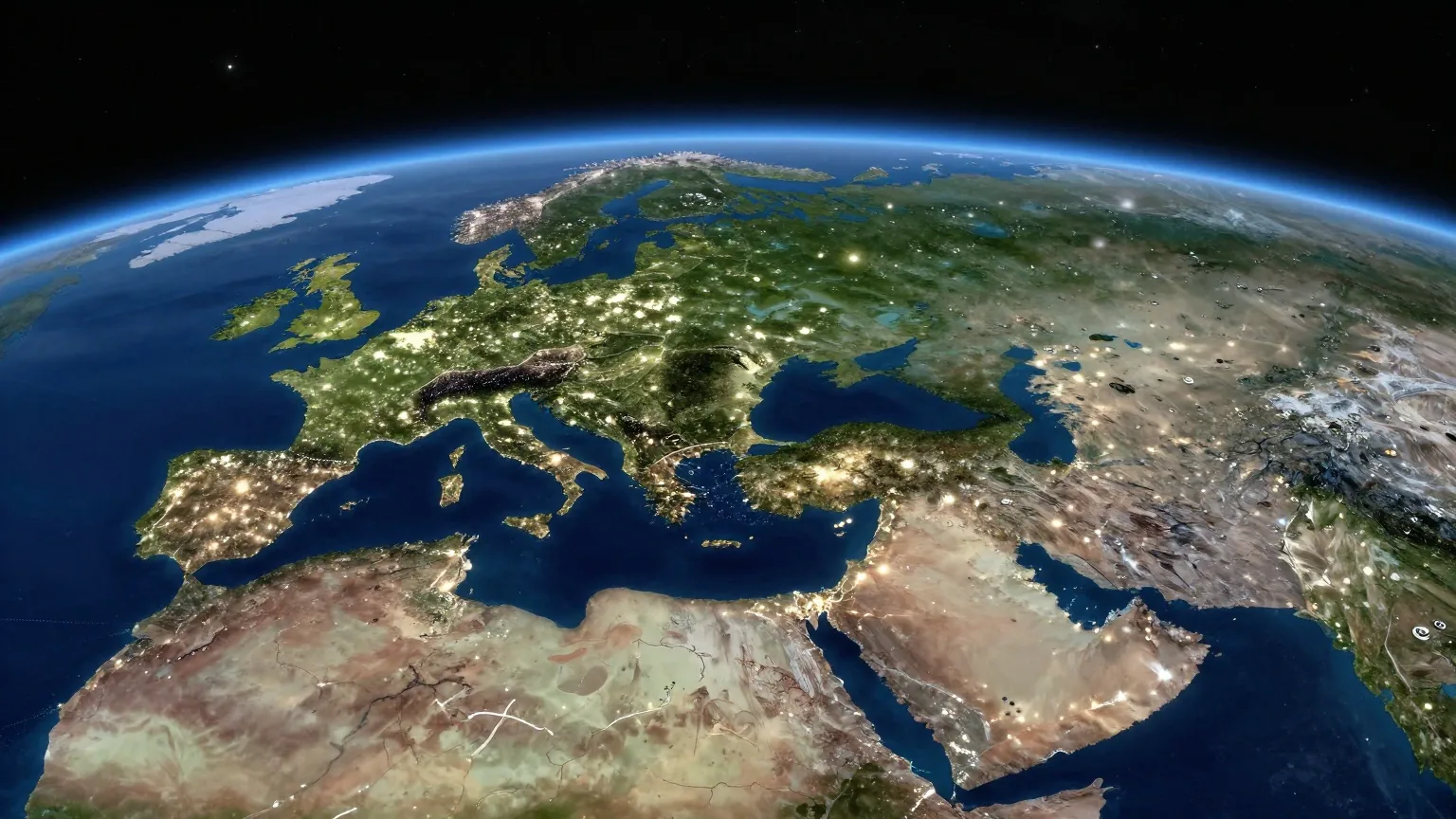 Die Erde bei Nacht aus dem All: Lichter der Städte entlang der Küsten Europas und Afrikas, am Horizont ein schmaler blauer Saum