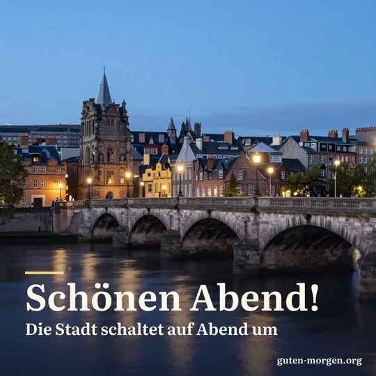 Alte Steinbrücke über einem Fluss in der Stadt zur blauen Stunde, Laternen spiegeln sich im Wasser; Schrift: „Schönen Abend! Die Stadt schaltet auf Abend um“
