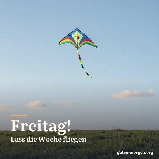 Bunter Drachen steigt am Morgen hoch über einer grünen Wiese, blauer Himmel mit ein paar Schäfchenwolken; Schrift: „Freitag! Lass die Woche fliegen“