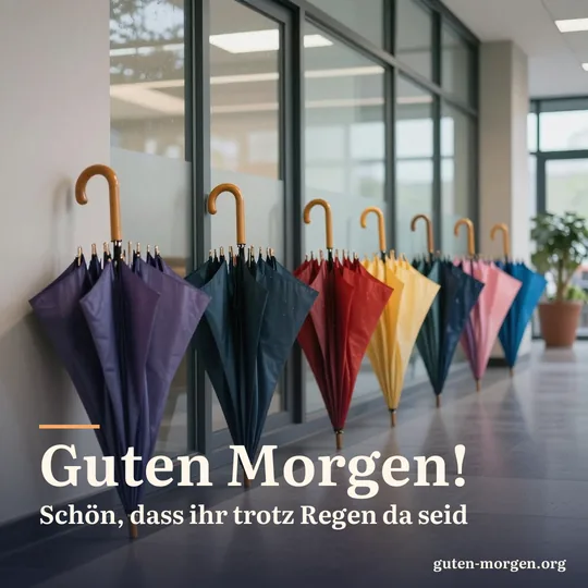 Bunte aufgespannte Regenschirme trocknen im Eingangsbereich eines Büros an einem regnerischen Morgen, weiches Licht spiegelt sich im glänzenden Boden; Schrift: „Guten Morgen! Schön, dass ihr trotz Regen da seid“